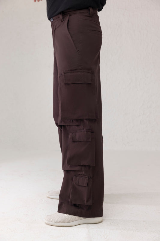 Side profile showing six funnel style side pockets on wide leg cargo pants in dark coffee brown