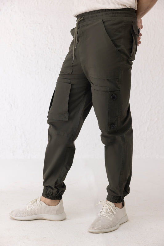 Side view of green twill cargo pants for men with black button detailing and tapered elastic hem