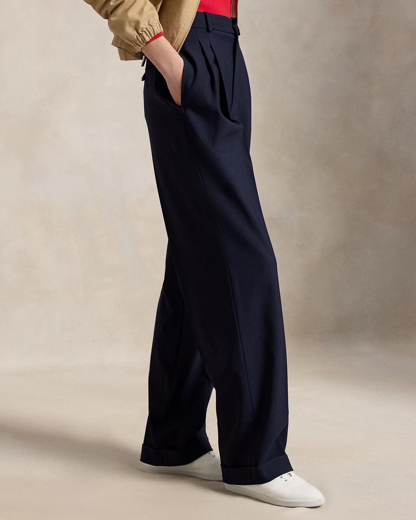 Person wearing navy wide-leg pants with a beige background