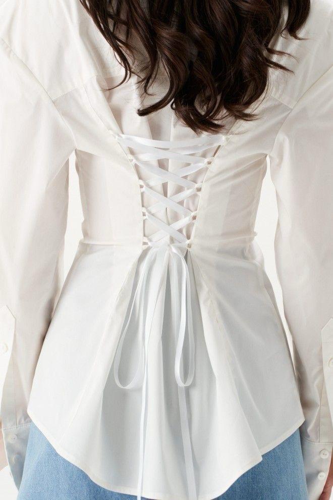 White blouse with a lace-up back design on a white background