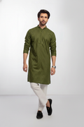 Man wearing a green kurta with white pajama on a light gray background