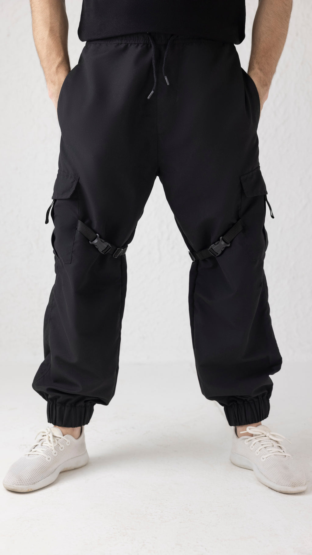Front view of Nyxbound Strap Utility Cargo Pants in black with elastic waist and clean athletic design
