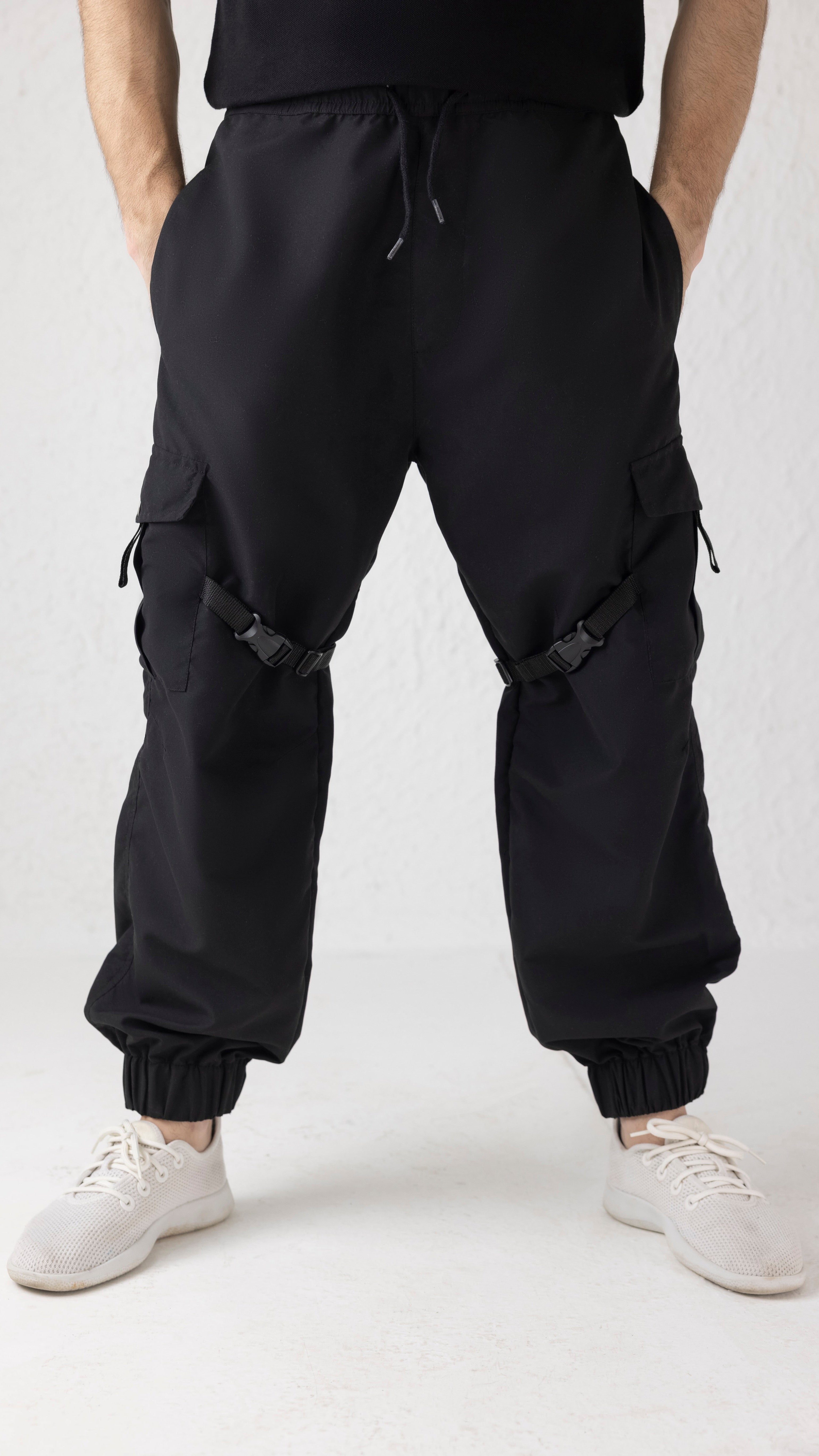 Front view of Nyxbound Strap Utility Cargo Pants in black with elastic waist and clean athletic design