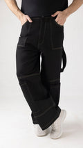 Close-up of light brown stitching and vertically belted side thigh detail on black denim cargo pants