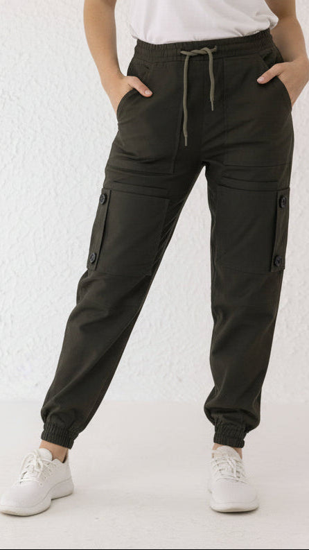 Front view of Thyron cargo pants in olive green twill with black thigh buttons and elasticated hems – Decuir